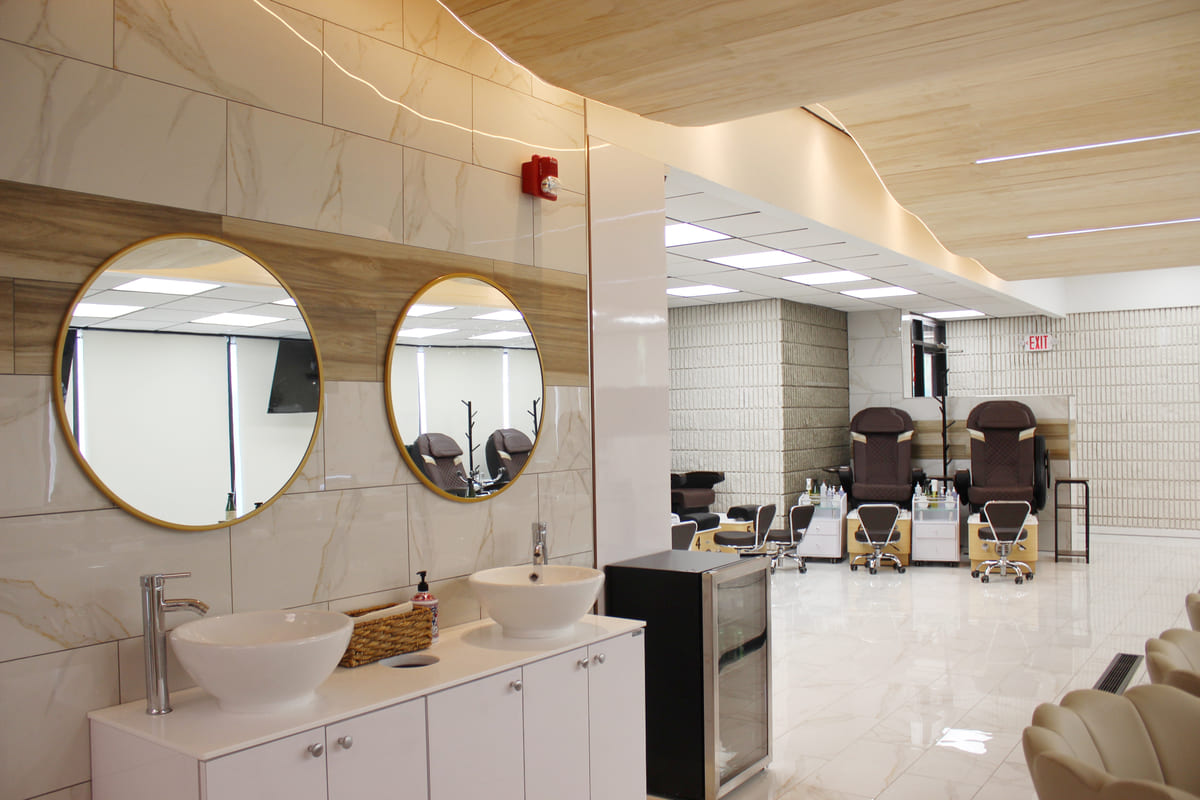 beauty in us salon fill with pedicure chairs, mirrors, and sinks